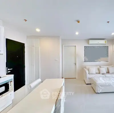 Modern living room with white sofa and open kitchen layout