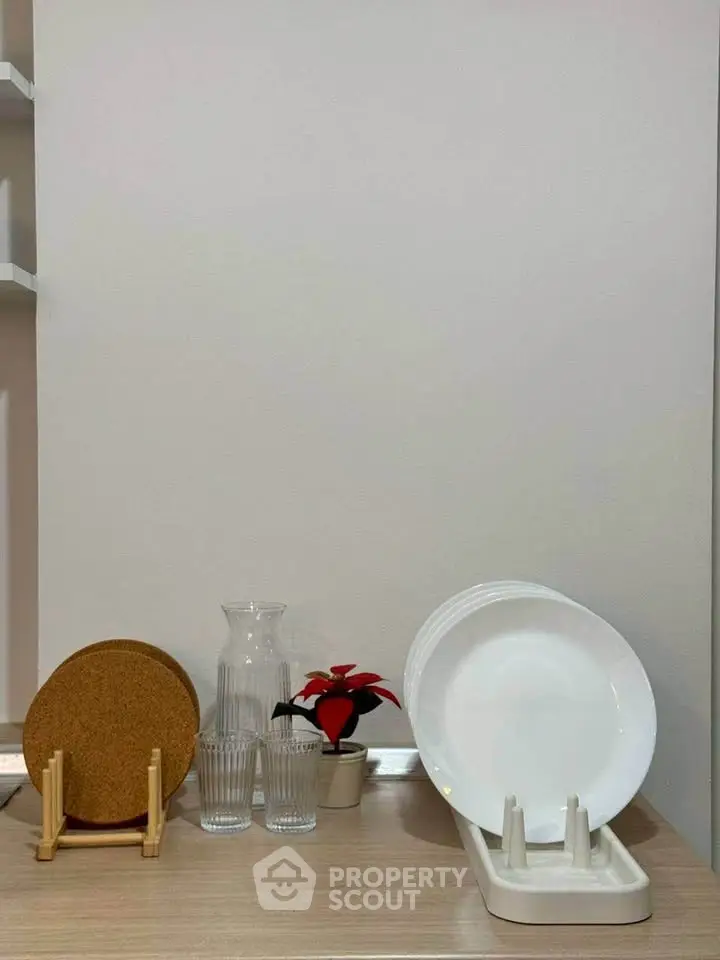 Modern kitchen countertop with dish rack and glassware, minimalist decor.