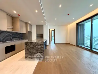 Spacious modern living room with open kitchen and stunning city view from large windows.