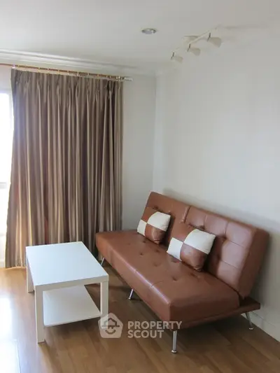 Cozy living room with brown leather sofa and white coffee table, perfect for relaxation.