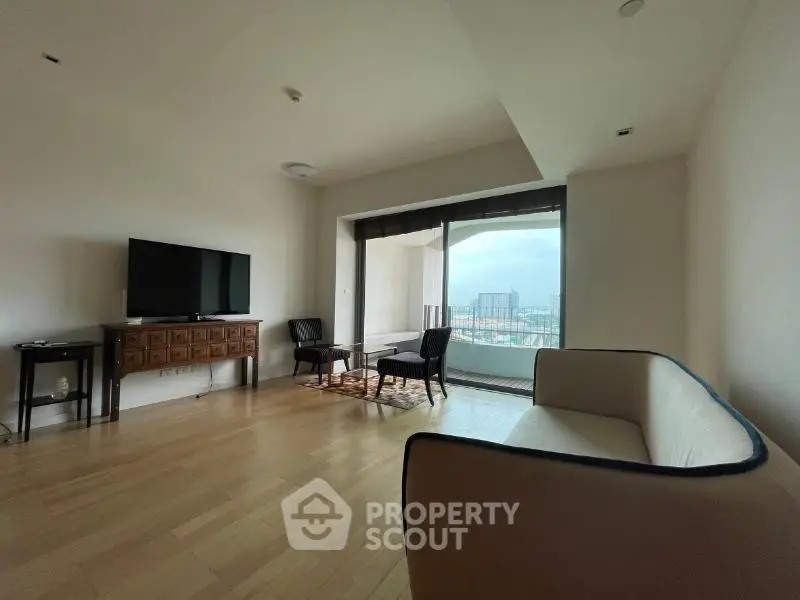 Spacious living room with modern furniture and large windows offering a stunning city view.
