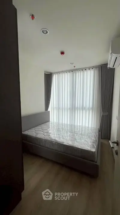 Modern bedroom with large window and stylish curtains in a contemporary apartment.