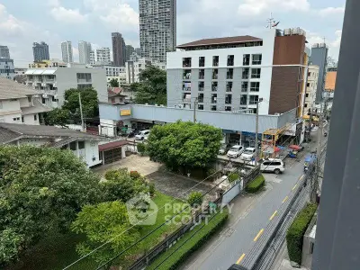 Urban cityscape view with residential and commercial buildings, showcasing vibrant city life and greenery.