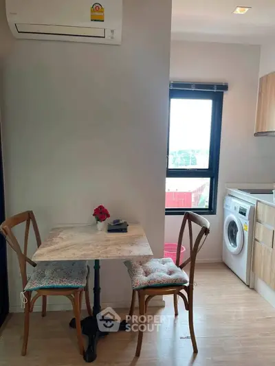 Cozy kitchen corner with dining set and washing machine in modern apartment
