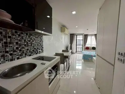 Modern studio apartment with sleek kitchen and cozy living area, ideal for urban living.