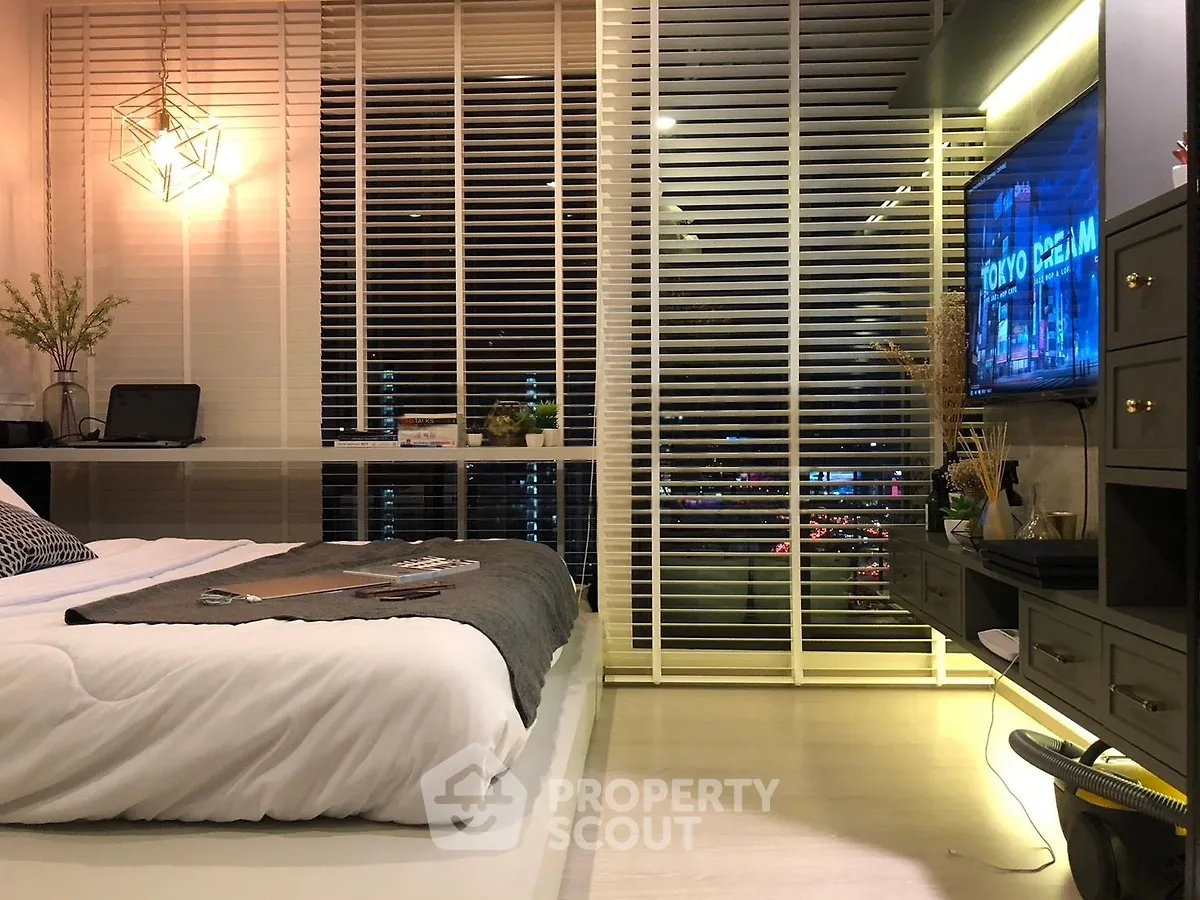 Modern bedroom with stylish decor and city view through large windows