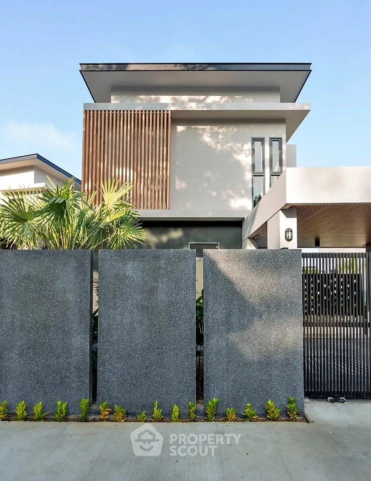 Modern two-story house with sleek design and lush greenery, featuring a stylish facade and contemporary architecture.