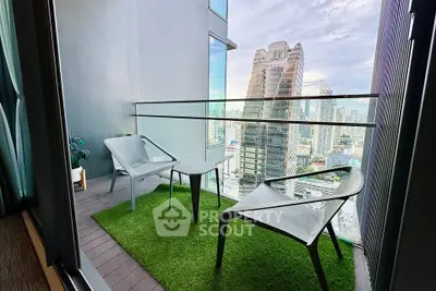 Modern balcony with city view, featuring sleek chairs and artificial grass flooring.