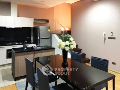 Modern kitchen and dining area with sleek design and stylish staircase