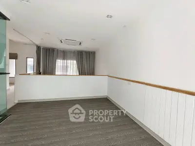 Spacious modern interior with elegant flooring and large window, perfect for versatile living space.