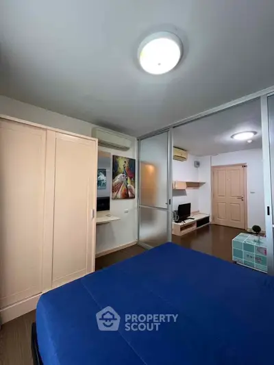 Modern bedroom with blue bedding, sliding closet doors, and stylish decor.
