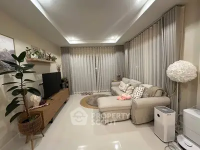 Modern living room with cozy sofa, stylish decor, and large windows with curtains.