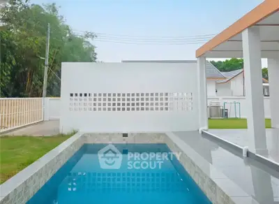 Modern outdoor pool with sleek design and spacious patio area in a serene residential setting.