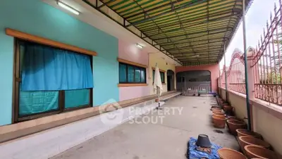 Spacious covered patio with colorful walls and potted plants, ideal for outdoor relaxation.
