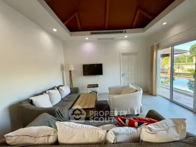 Spacious living room with modern furniture and pool view