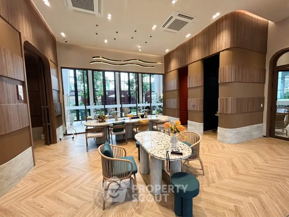 Luxurious modern living room with elegant decor and large windows offering garden views.