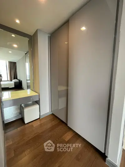 Modern bedroom with sleek wardrobe and wooden flooring