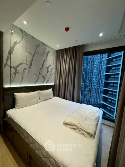 Modern bedroom with marble accent wall and city view from large window.