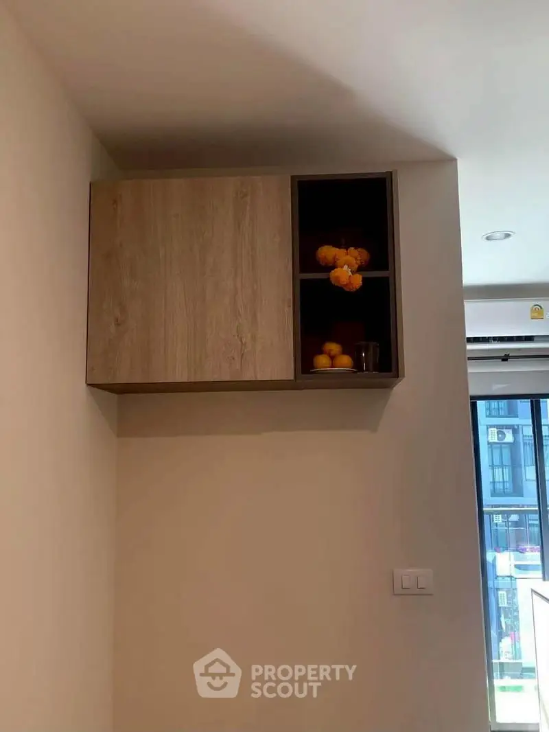 Modern kitchen cabinet with open shelving and decorative items in a stylish apartment.