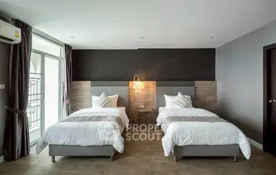 Modern bedroom with twin beds and stylish decor in a contemporary apartment.