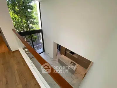 Stunning modern interior with high ceilings and large windows offering natural light and garden view.