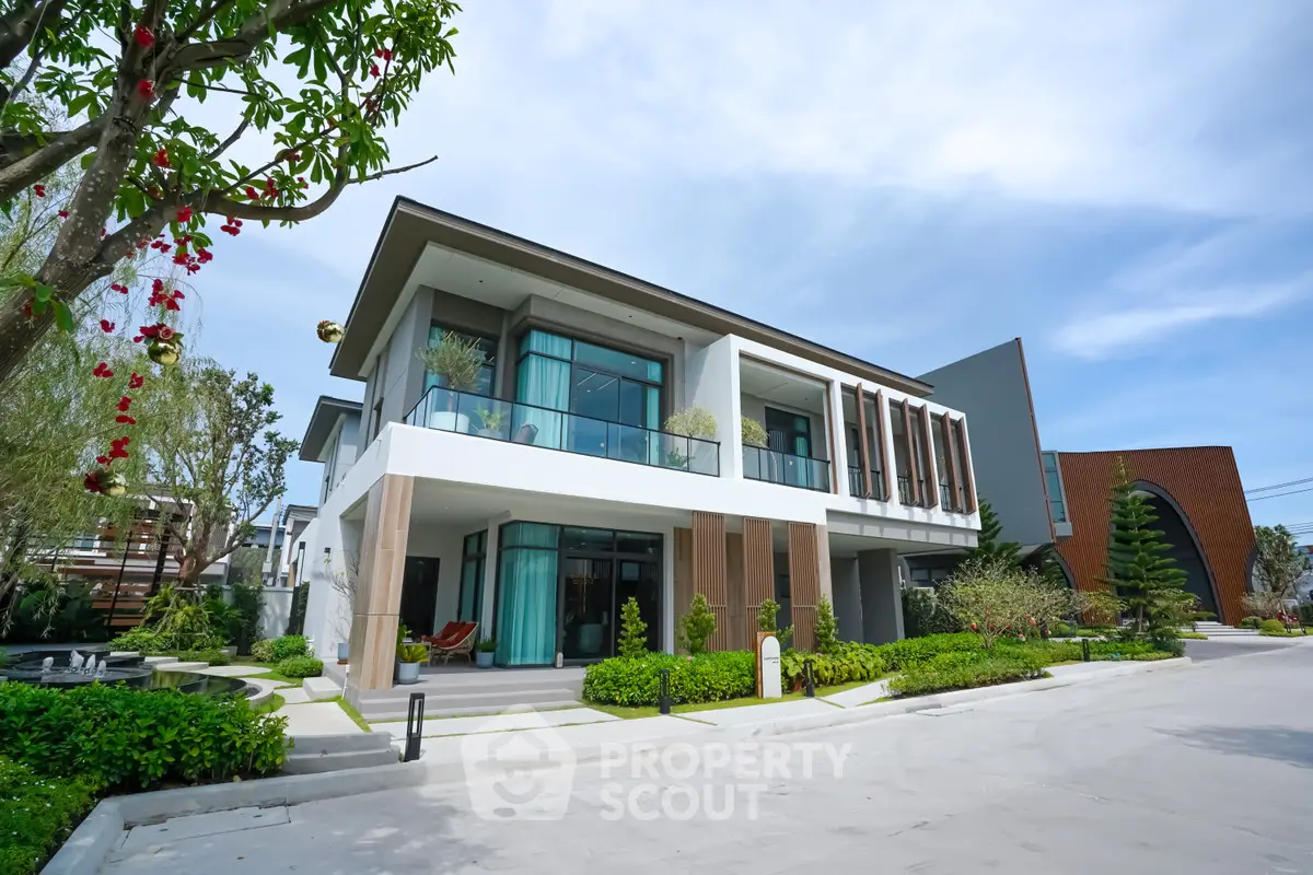 Modern luxury house with large windows and landscaped garden in a serene neighborhood.