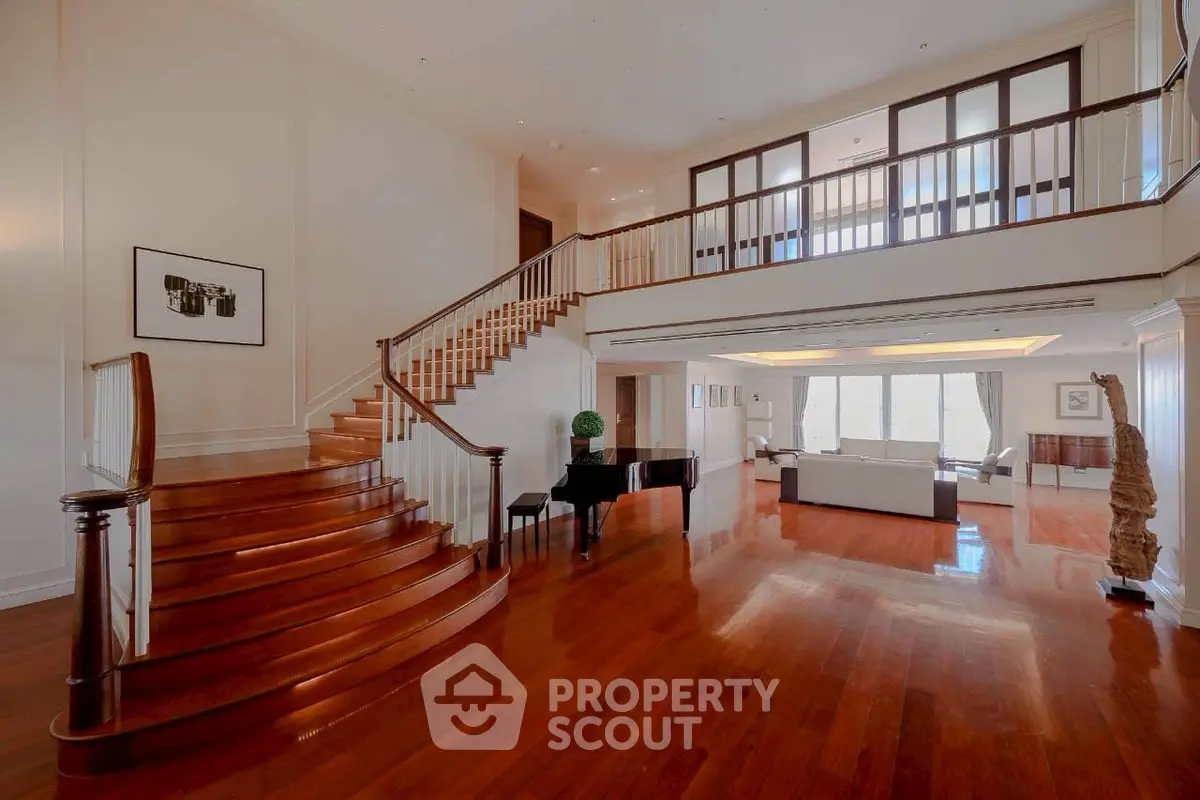 Luxurious open living room with grand staircase and elegant wooden flooring