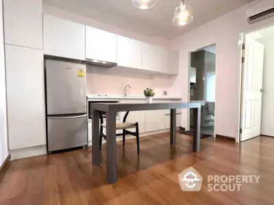 Modern kitchen with sleek cabinetry and stainless steel fridge in open layout