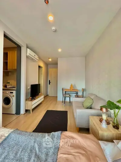 Modern studio apartment with cozy living area, compact kitchen, and stylish decor.