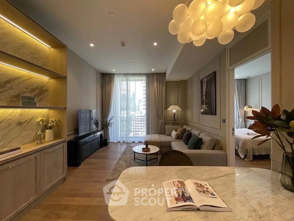 Luxurious open-plan living room with elegant decor and modern lighting, featuring a cozy seating area and stylish kitchen.