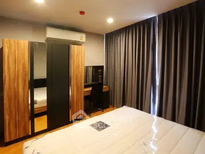 Modern bedroom with stylish wardrobe and study desk, featuring sleek design and ample natural light.