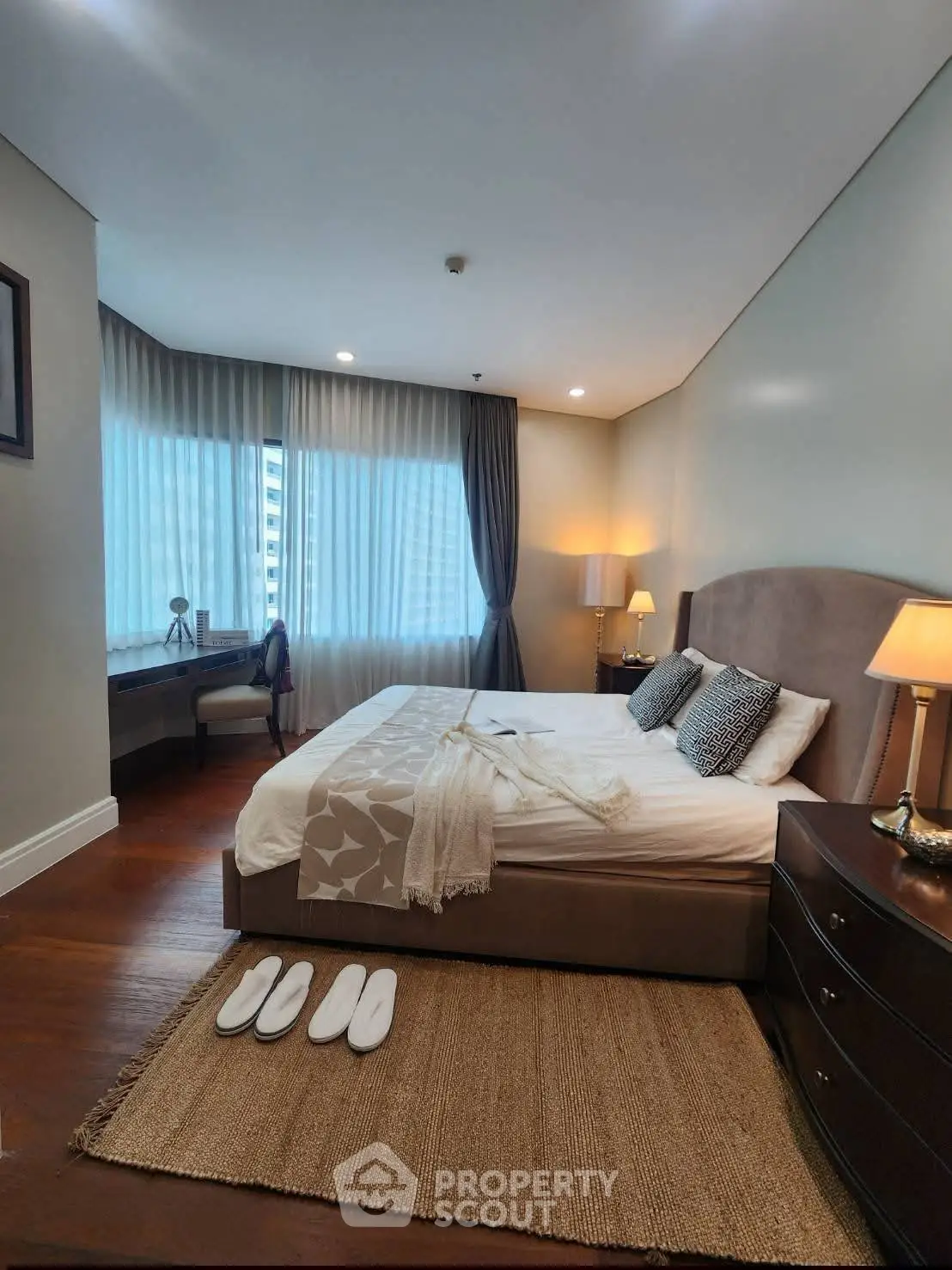 Luxurious bedroom with elegant decor and large windows in a modern apartment.