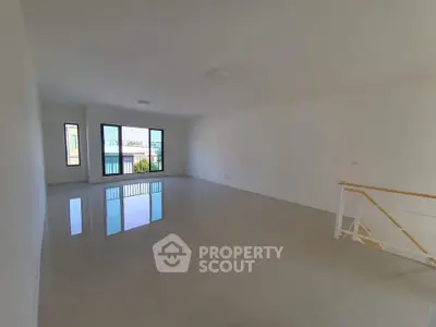 Spacious modern living room with large windows and glossy tiled floors.