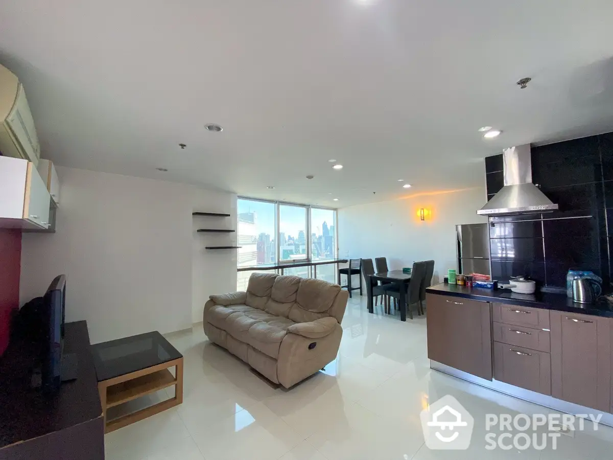 Spacious open-plan living area with gleaming tiled floors, modern kitchen, and plush seating, boasting ample natural light and city views.