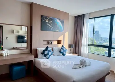 Modern bedroom with city view, stylish decor, and natural light.