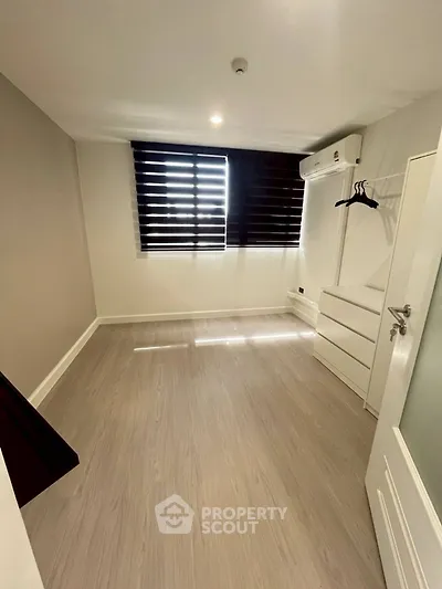 Spacious bedroom with modern flooring and air conditioning