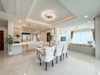Luxurious open-plan living and dining area with elegant decor and modern lighting