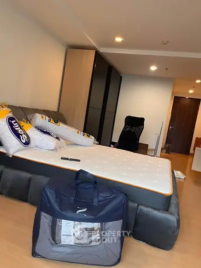 Spacious bedroom with modern furniture and cozy lighting, featuring a comfortable bed and sleek wardrobe.