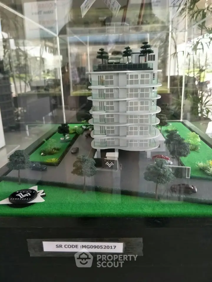 Modern architectural model of a futuristic building with lush landscaping and sleek design.