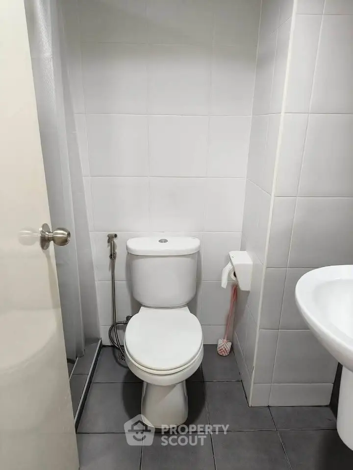 Modern bathroom with sleek white tiles and contemporary fixtures.