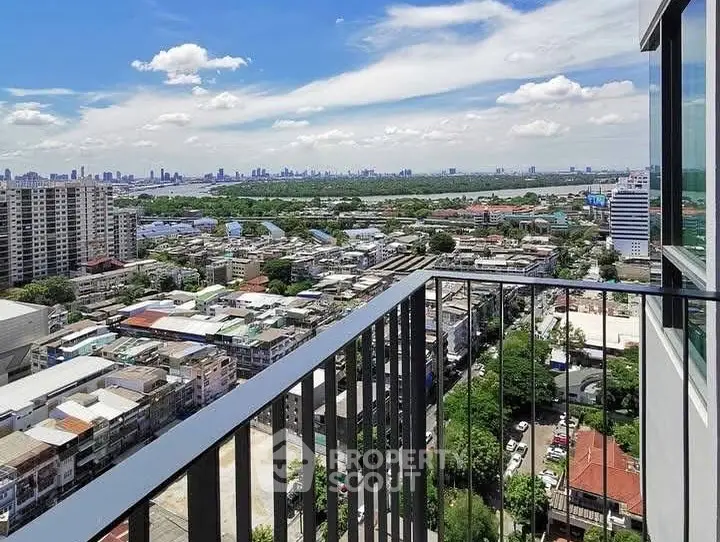 Stunning cityscape view from high-rise balcony with clear blue skies.