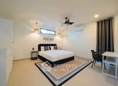 Spacious modern bedroom with elegant decor and ample natural light.