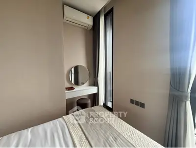 Cozy bedroom with modern decor and natural light, featuring a stylish vanity and air conditioning.