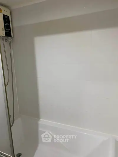 Modern bathroom with sleek white tiles and built-in bathtub, perfect for relaxation.
