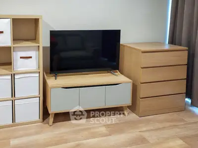 Modern living room with stylish wooden furniture and flat-screen TV, perfect for cozy relaxation.