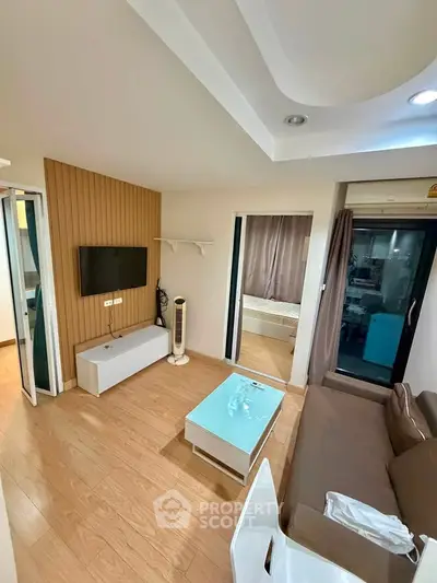 Modern living room with wooden flooring and sleek furniture in a cozy apartment.