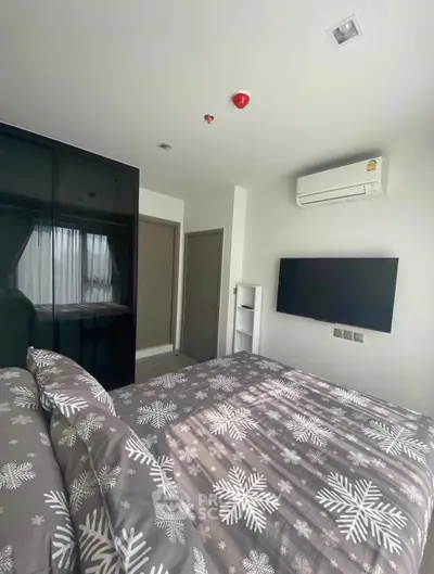 Modern bedroom with stylish decor, featuring a wall-mounted TV and air conditioning for comfort.