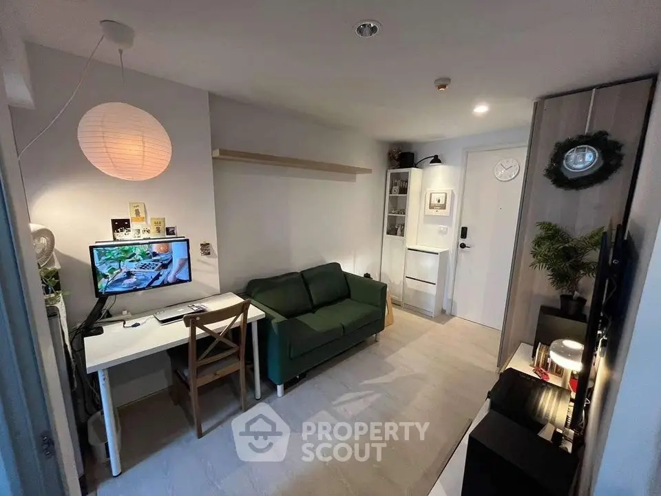 Cozy modern living room with green sofa, workspace, and stylish decor