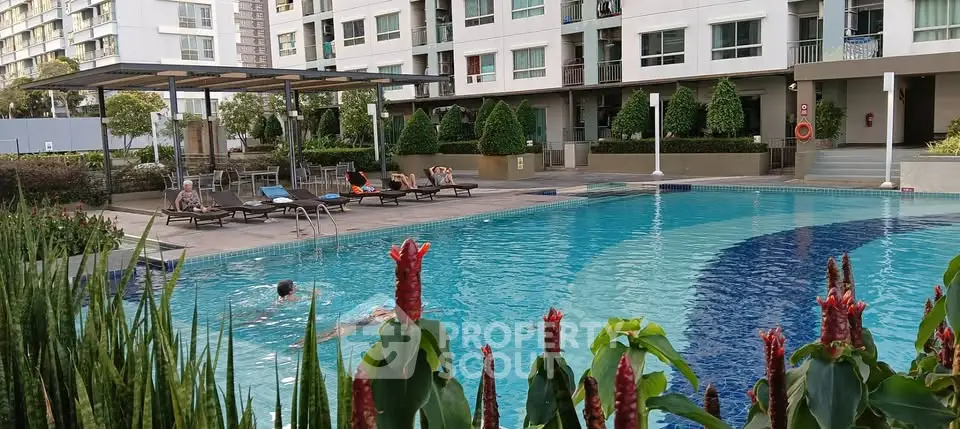 Luxurious apartment complex with inviting outdoor pool and sun loungers, perfect for relaxation and leisure.