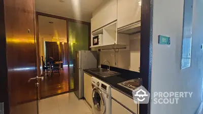 Modern apartment kitchen with washing machine and sleek cabinetry